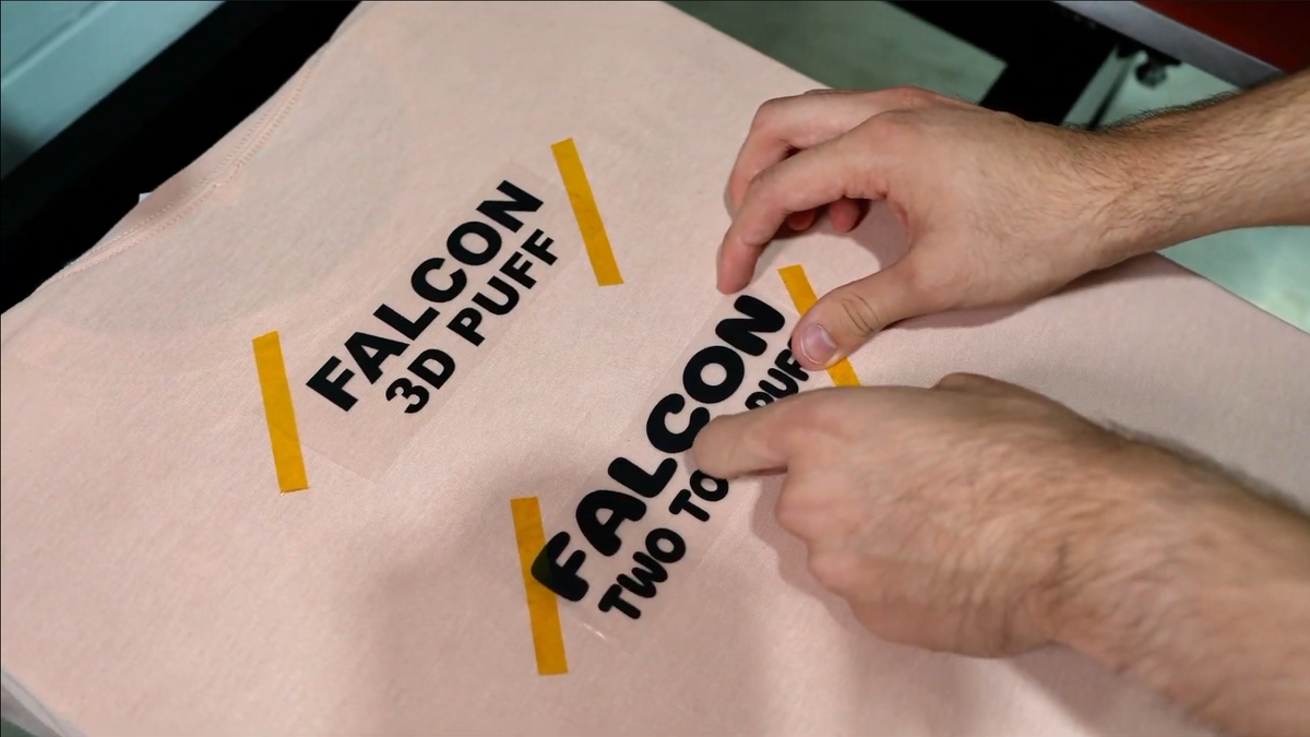 Heat press positioned over a DTF transfer on a garment